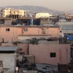The image, from the cover of the report, is a close-up of dense housing. Some of the houses have satellite dishes and clothes drying on a line.