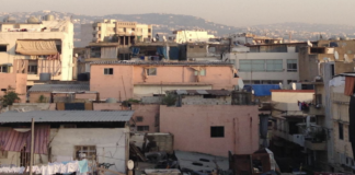 The image, from the cover of the report, is a close-up of dense housing. Some of the houses have satellite dishes and clothes drying on a line.